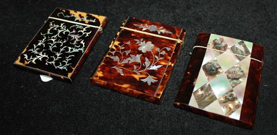 Three tortoiseshell & mother of pearl card cases, one enamel-banded (a.f), one with abalone lozenges, one with floral panel